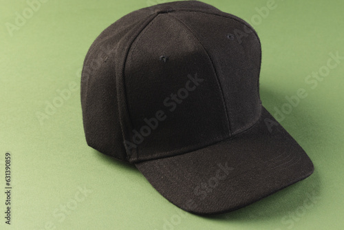 Black baseball cap and copy space on green background