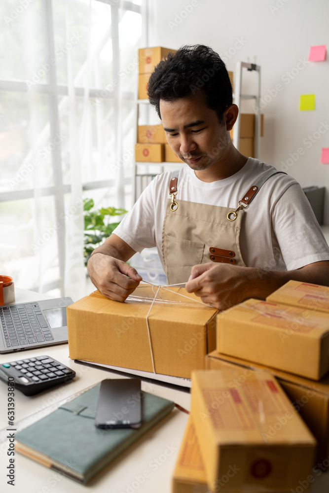 Male owner of an online store packs products into parcel boxes based on orders from online sales sites, packs products for delivery to addresses via private courier service. Product packaging concept. Male owner of an online store packs products into parcel boxes based on orders from online sales sites, packs products for delivery to addresses via private courier service. Product packaging concept.