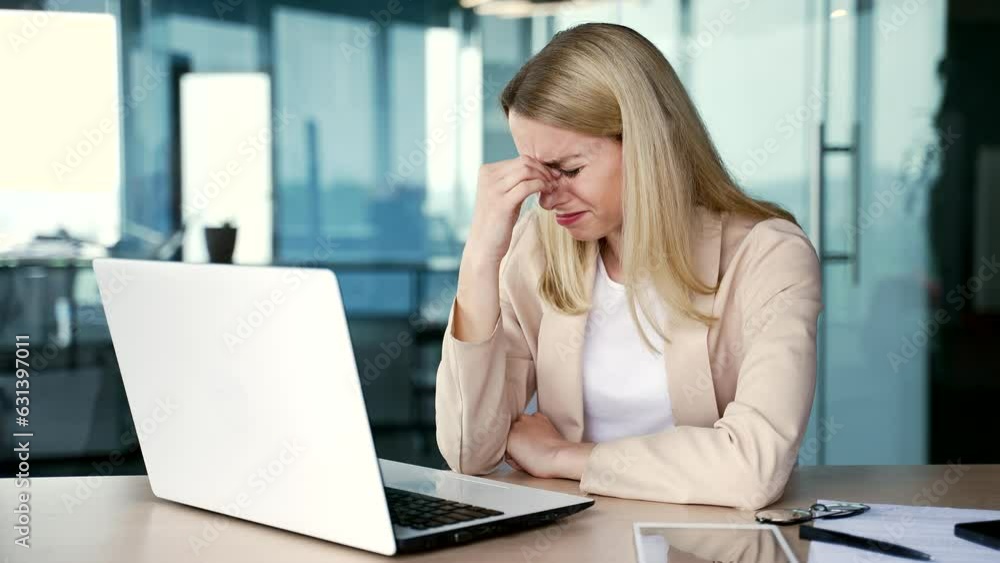 Sad young female employee crying and suffering from mental pain sitting at workplace in modern office. A disappointed woman has problems at work, worries, feels despair, disappointment and depression Sad young female employee crying and suffering from mental pain sitting at workplace in modern office. A disappointed woman has problems at work, worries, feels despair, disappointment and depression