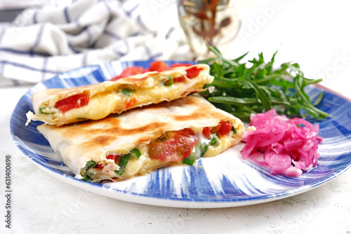 Tasty breakfast with quesadilla and eggs. Mexican cuisine. Trending food with pita bread, omelet, cheese, tomatoes