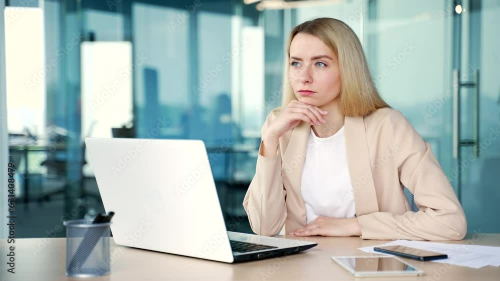 Young businesswoman showing raised index finger up gesture in moment of inspiration of new idea while working on laptop while sitting in modern office. Employee found the answer to solve the problem Young businesswoman showing raised index finger up gesture in moment of inspiration of new idea while working on laptop while sitting in modern office. Employee found the answer to solve the problem