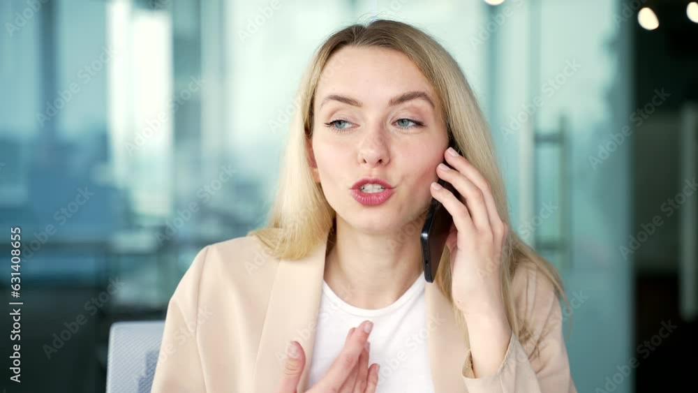Close up. Happy businesswoman talking on smartphone while sitting at workplace at desk in modern office. Smiling female employee discusses business with a colleague or has a conversation with a friend Close up. Happy businesswoman talking on smartphone while sitting at workplace at desk in modern office. Smiling female employee discusses business with a colleague or has a conversation with a friend