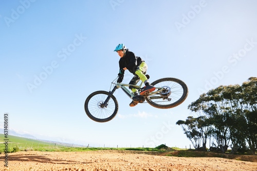 Fototapeta Naklejka Na Ścianę i Meble -  Mountain bike, man and jump in blue sky for action, stunt performance and speed on mockup space. Bicycle, sports athlete and courage in air for freedom, risk or race in cycling competition with power