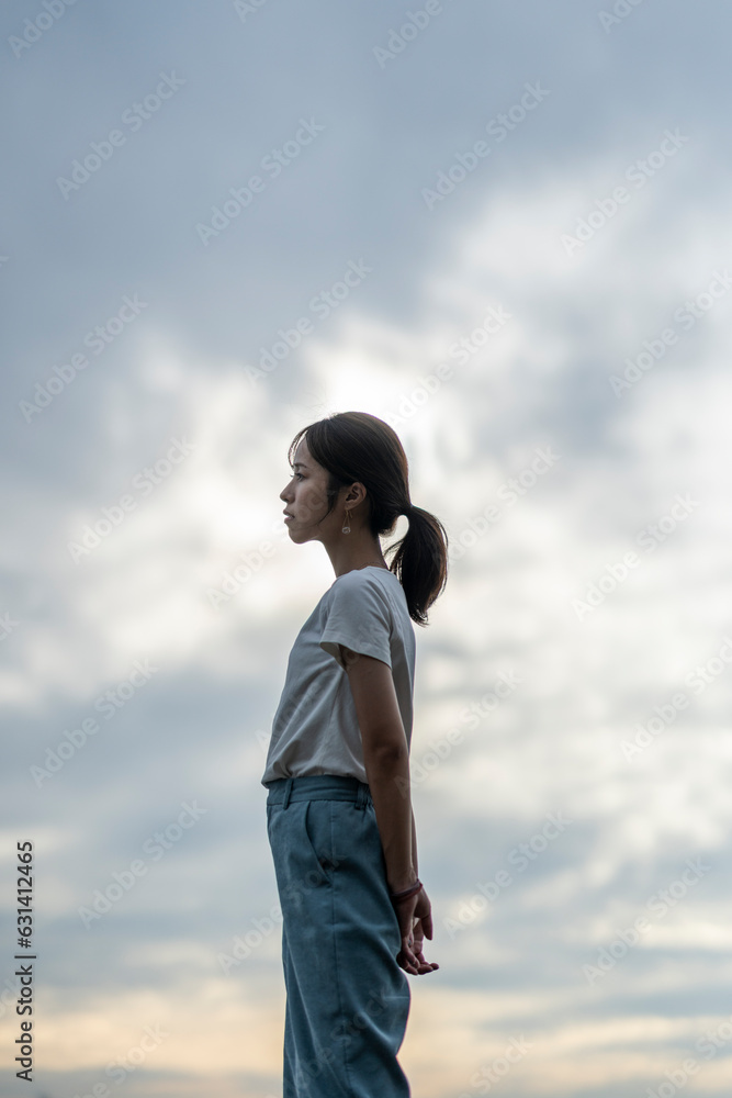 夕暮れの海にいる女性