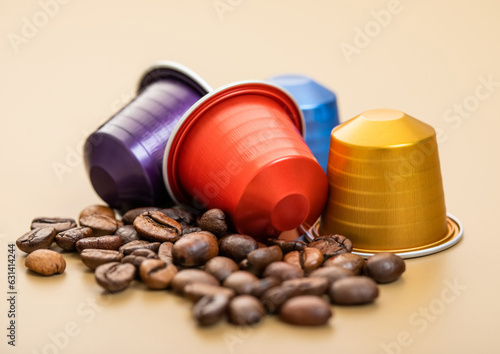 Aluminium capsules of natural organic coffee suitable with raw aroma bean on beige background.