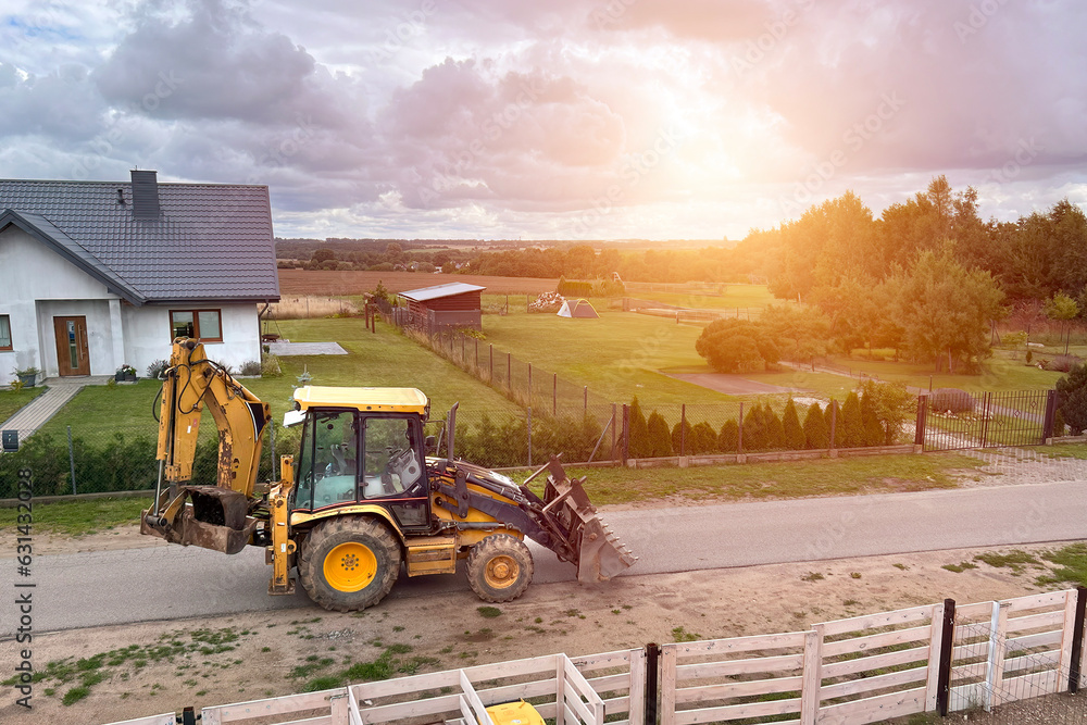 Yellow tractor. Mini excavator bulldozer. Earthmoving company in the rural area.
