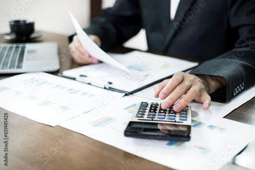 The business hand sits at their desks and calculates financial graphs showing the results of their investments planning the process of successful business growth