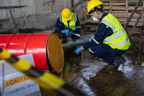 Two officers wearing gas masks inspected the area of a chemical leak in an industrial warehouse to assess the damage. Technicians wearing gas masks inspect and assess the recovery of toxic spills..
