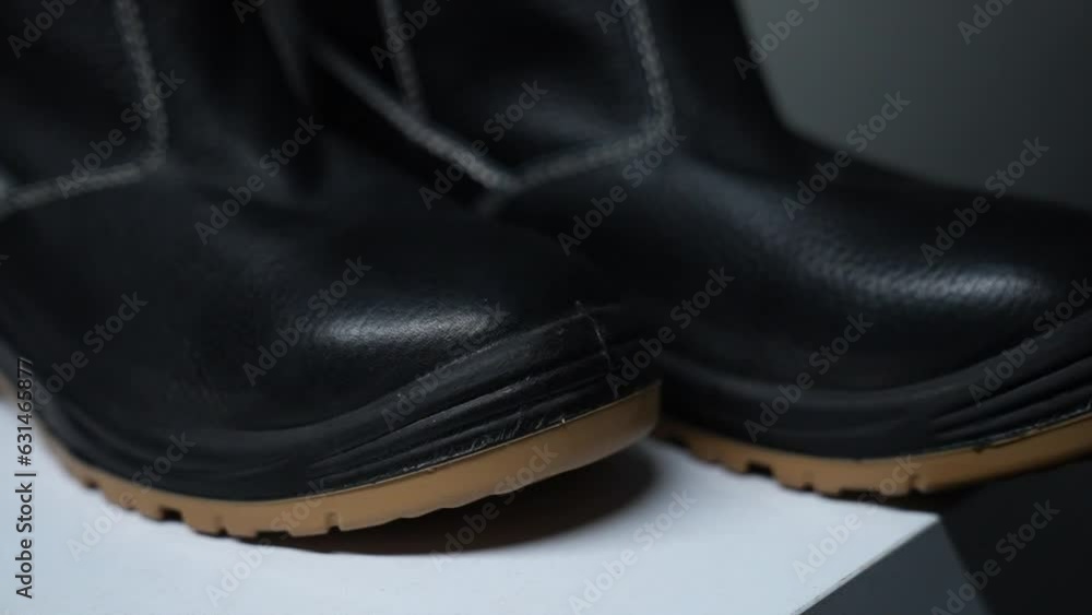 a black leather waterproof boot shoots from a different angle against a light black background
a black leather waterproof boot shoots from a different angle against a light black background