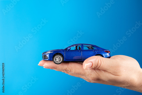 Buying a car, Motor vehicle rent, Lease or purchase, car in hand on a blue background, copy space