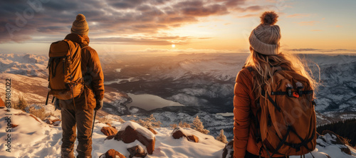 Two hikers admiring a scenic view from a snowy mountain top. Adventurous young man and woman with backpacks. Hiking and trekking on a nature trail. Traveling by foot. © MNStudio