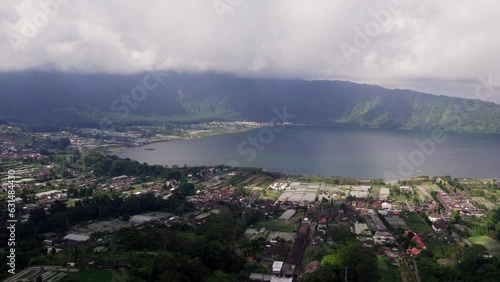 Bird's Eye View of Bali Village, Lake, and Cloud-Capped Mountains - 4K Drone Footage of Scenic Rural Landscape and Wilderness