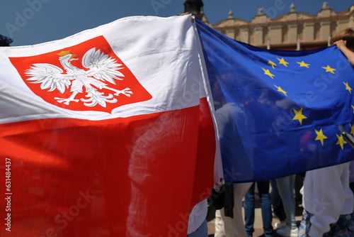 National flag of Poland tied together with flag of European Union waves during demonstration