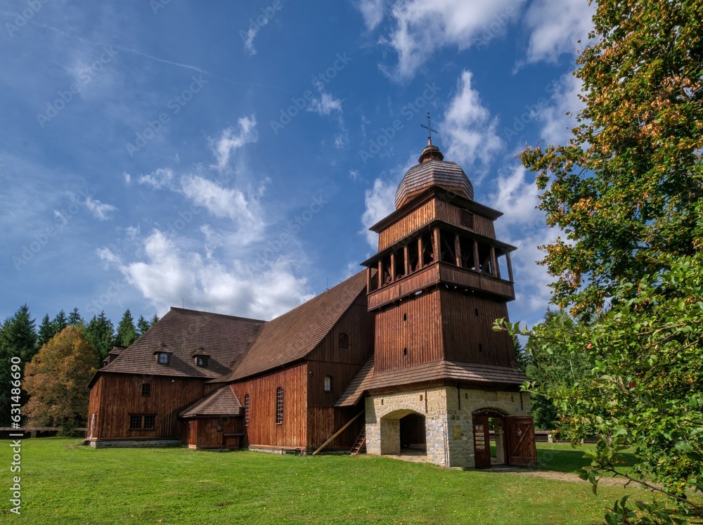 Wooden evangelical articular church of the Svaty Kriz(Holy Cross), is one of the largest wooden churches in Europe.Green meadow, blue sky white clouds, old architecture. Paludza, Svaty Kriz. Wooden evangelical articular church of the Svaty Kriz(Holy Cross), is one of the largest wooden churches in Europe.Green meadow, blue sky white clouds, old architecture. Paludza, Svaty Kriz.