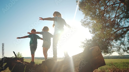 children playing in the park. small children walk on fallen log in a forest park in a children camp. happy family kid concept. a group of children walk on fallen tree and play in forest park dream