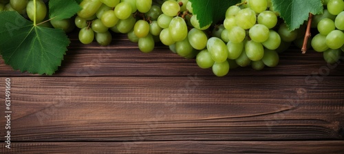 Green juicy grapes on wooden background.