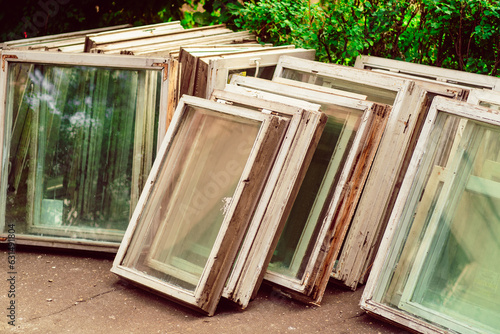 Bunch of old wooden windows frames on the street. Replacement of windows, reconstruction