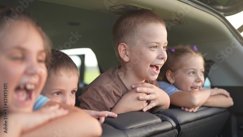 baby kids rejoice in caravanning camping. happy family journey kid dream concept. a group of children sitting in the back seat of the car screaming into the open trunk. travel concept lifestyle