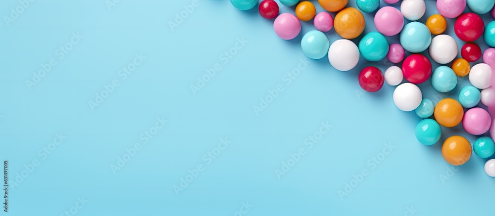 Obraz premium Colorful candy balls are displayed on a blue paper background in the format of a horizontal