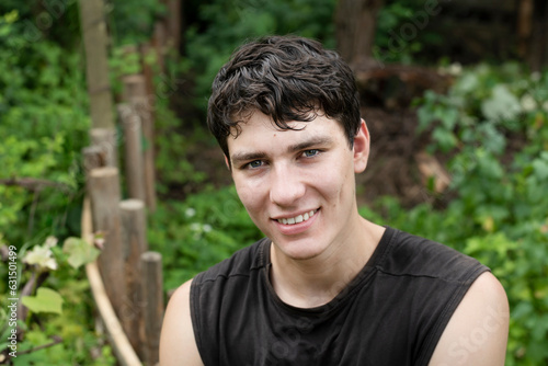 Portrait of a young successful guy of 18 years old, he is positive and smiling, he finished training outdoors and resting in the park