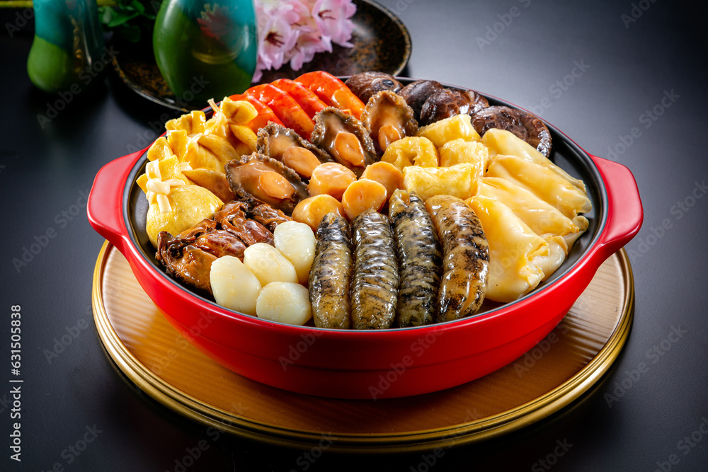 traditional asian luxury treasure premium seafood Peng cai abalone, sea cucumber, scallop, prawn, oyster, mushroom in hot clay pot on red table for Chinese new year cuisine halal banquet food menu