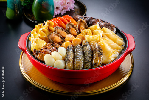 Obraz na płótnie traditional asian luxury treasure premium seafood Peng cai abalone, sea cucumber, scallop, prawn, oyster, mushroom in hot clay pot on red table for Chinese new year cuisine halal banquet food menu w salonie