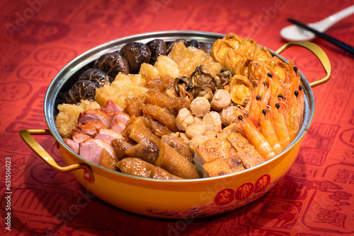 traditional asian luxury treasure premium seafood Peng cai abalone, sea cucumber, scallop, prawn, oyster, mushroom in hot clay pot on red table for Chinese new year cuisine halal banquet food menu