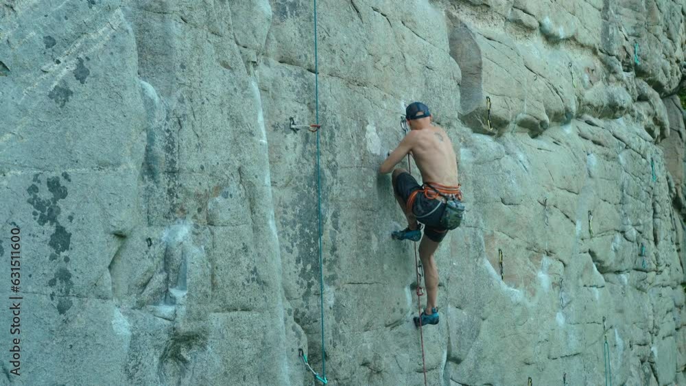 strong man rockclimber climbing on tough sport route, searching, reaching and gripping hold. climber makes a hard move and clipping rope. outdoors rock climbing and active lifestyle strong man rockclimber climbing on tough sport route, searching, reaching and gripping hold. climber makes a hard move and clipping rope. outdoors rock climbing and active lifestyle