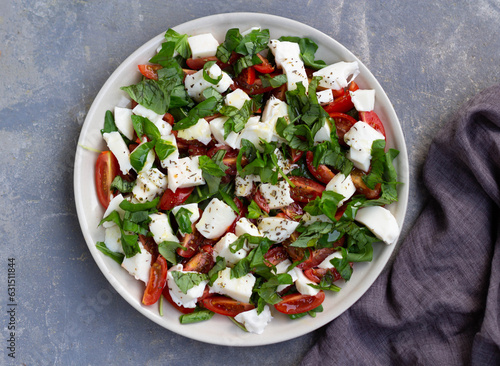 Caprese salad with tomatoes, feta cheese on a plate. Top view