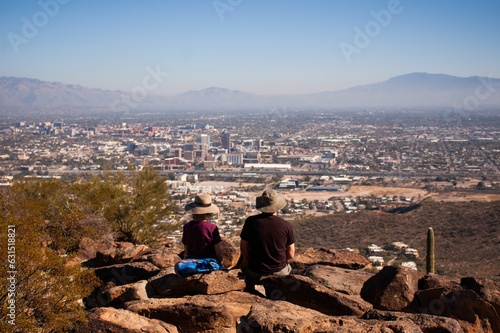 Hikers sitting on top of Tumamoc hill overlooking downtown Tucson Arizona