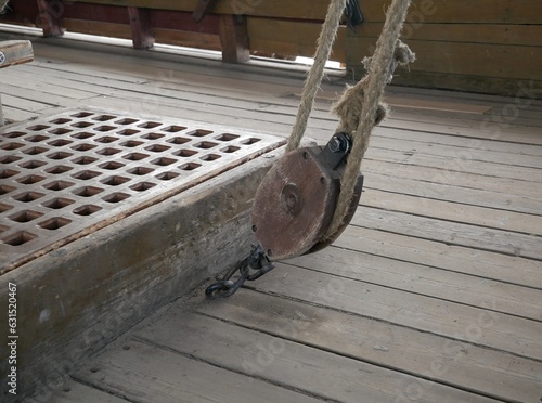 Rope made of natural materials on a wooden block on the deck of an ancient ship. Rigging on a ship made according to ancient technologies.