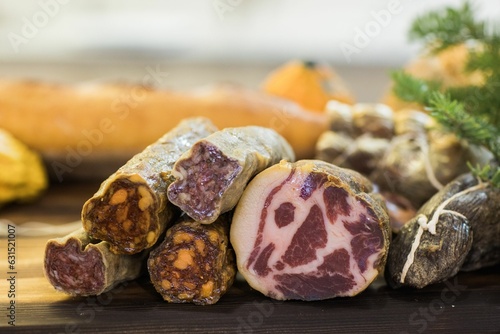 Closeup shot of various uncut deli meats on a wooden board photo