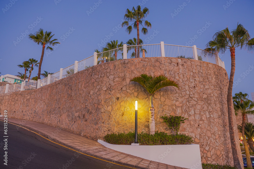 Naklejka premium Beautiful view of fenced hotel area at top of mountain hill on evening sky background. Spain. Gran Canaria.