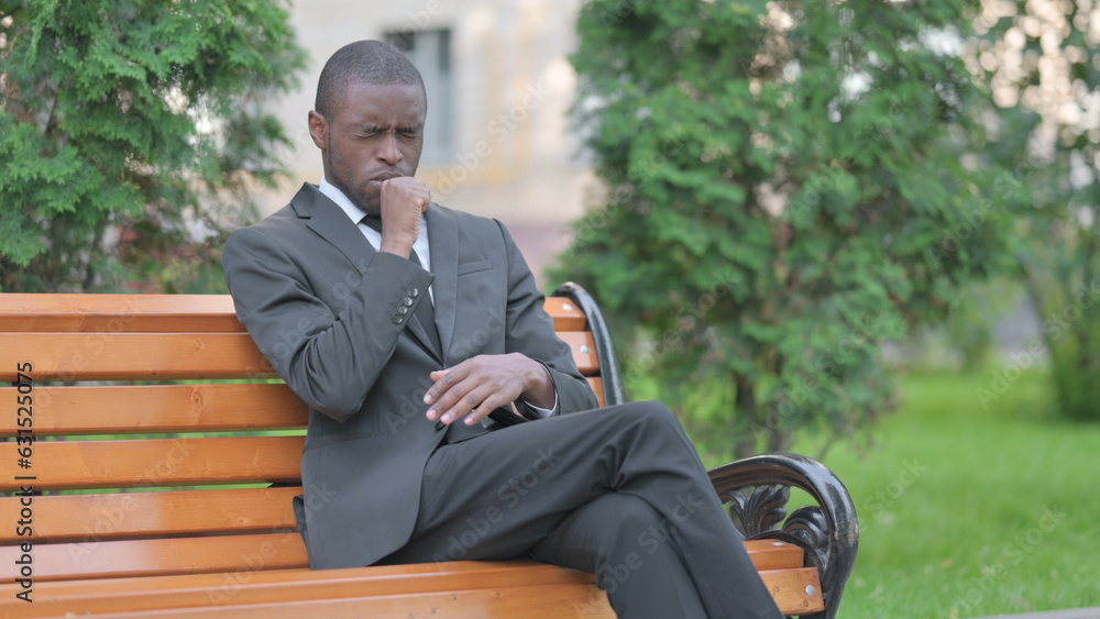 Obraz premium Coughing African Businessman Sitting Outdoor
