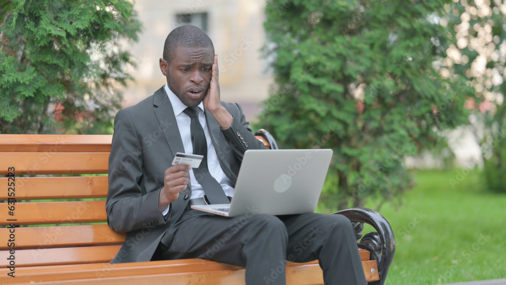African Businessman Upset by Online Payment Failure on Laptop Outdoor African Businessman Upset by Online Payment Failure on Laptop Outdoor