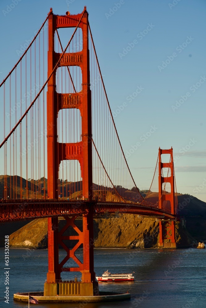 Golden Gate Bridge at sunset with ship passing Golden Gate Bridge at sunset with ship passing
