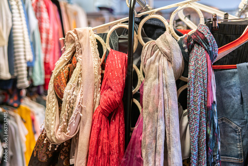 Sweden, Malmo – July 8, 2023: Different clothes on hangers, hanging clothes in second hand store photo