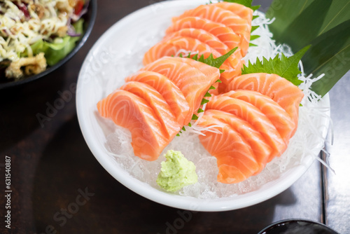 Fresh sliced salmon or salmon sashimi with in white bowl set on table, Japanese food.
