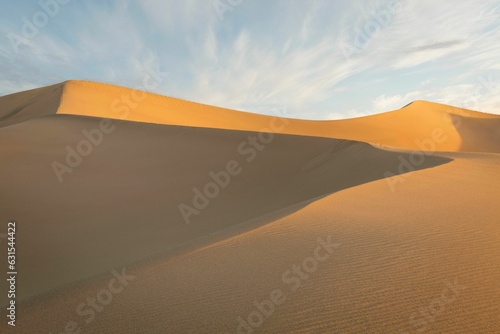 Vast expanse of golden sand with a deep blue sky in the background