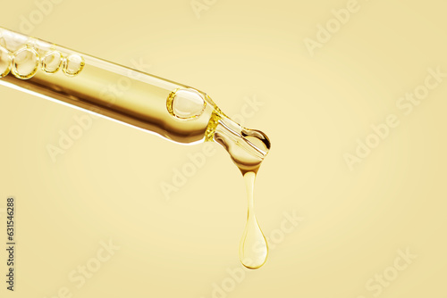 Fotografie Cosmetic pipette with a falling drop of gold color on a yellow yellow background