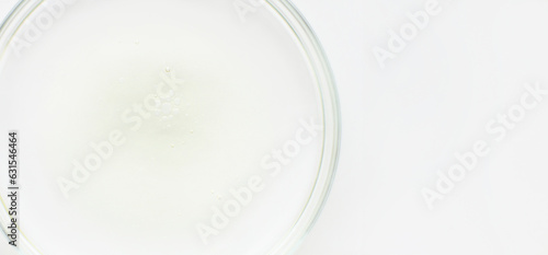 Petri dish with liquid and small bubbles on a light background
