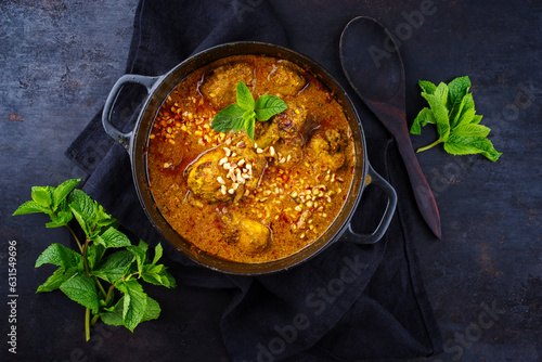 Traditional spicy Indian chicken Madras curry Rogan Josh with drumsticks and rice served as top view in a Nordic design bowl with copy space photo