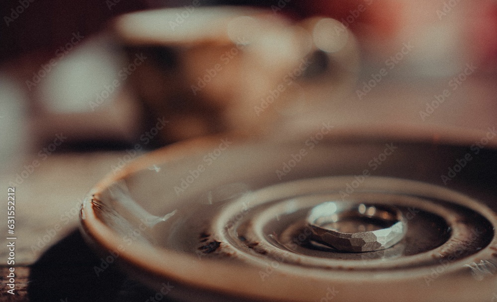 Macro shot of a ring resting on a ceramic saucer Macro shot of a ring resting on a ceramic saucer