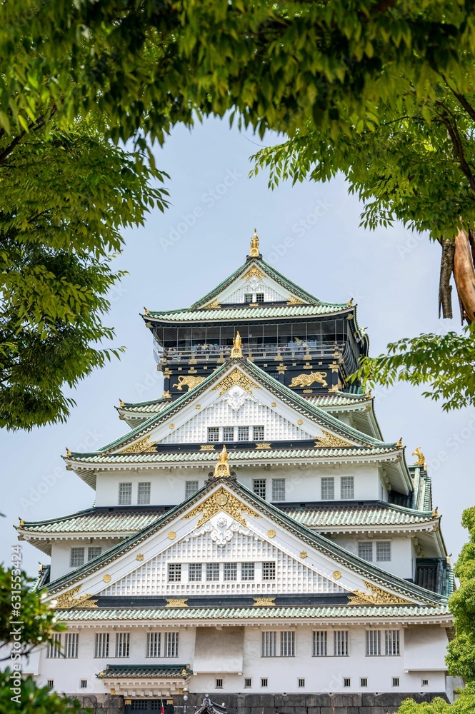 Grand Osaka Castle framed with lush vegetation Grand Osaka Castle framed with lush vegetation