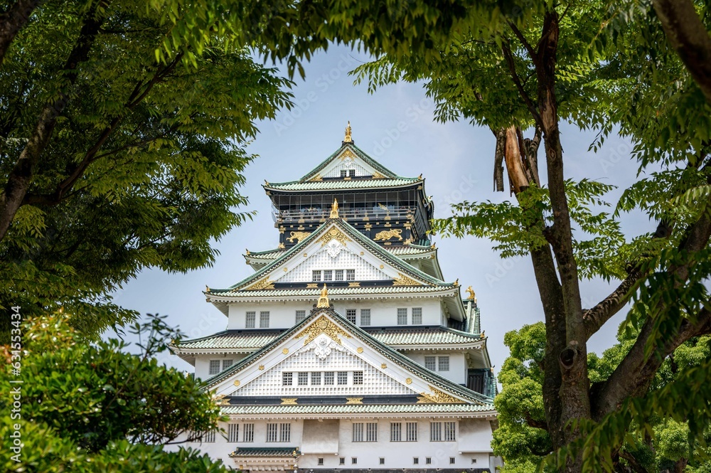 Large grand castle in Osaka, Japan, surrounded by an abundance of lush green vegetation