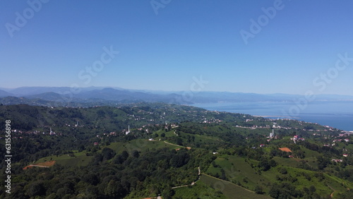 Aerial shot of the sea and mountains and houses in green villages in the countryside of Rize