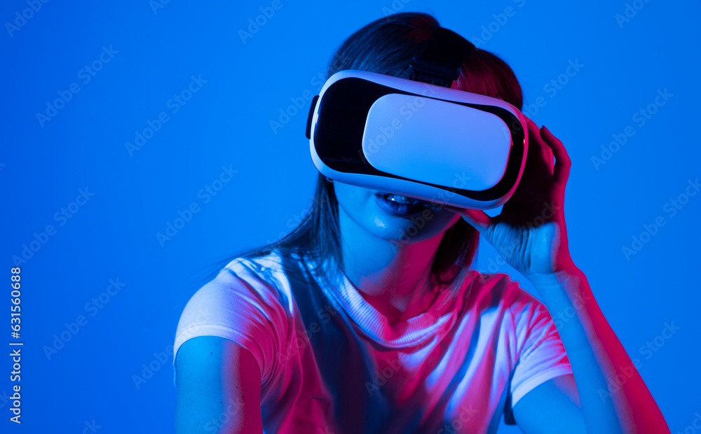 Woman in VR headset using finger to touch on imaginary panel viewing on VR device. VR is a computer technology that simulates a physical presence and allows to interact with environment. Woman in VR headset using finger to touch on imaginary panel viewing on VR device. VR is a computer technology that simulates a physical presence and allows to interact with environment.
