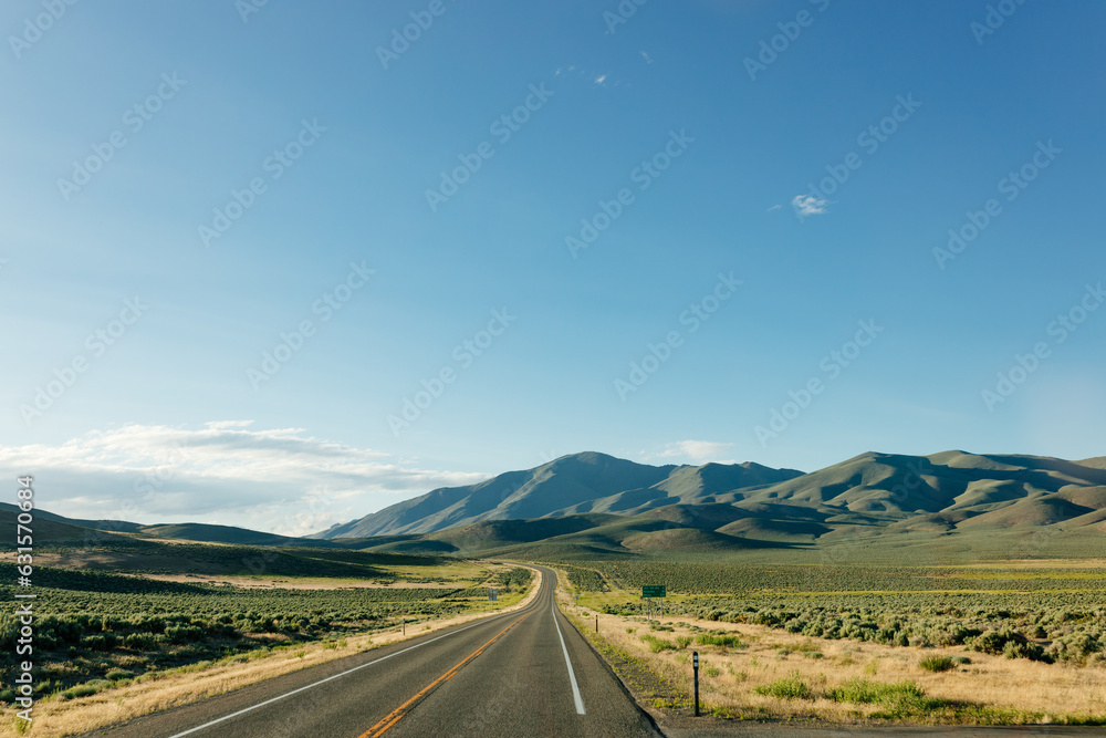 Φωτογραφία Beautiful road landscape with road signs, mountains, highway and blue sky with fluffy clouds on a sunny summer day