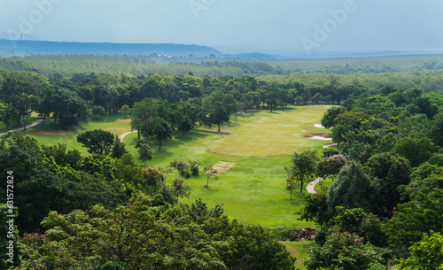 Majestic golf course nestled in the embrace of an evergreen forest  with ethereal fog merging into the vast sky.