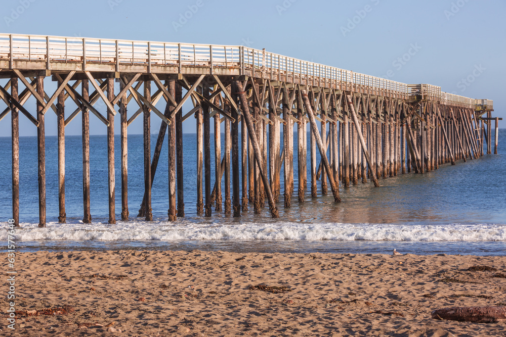 Waves crashing under a wooden pier in California